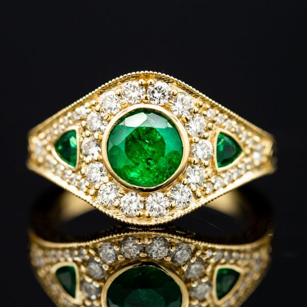This gorgeous Art Deco-inspired ring sparkles with diamond accents, but the heart of the ring is a bright green emerald.