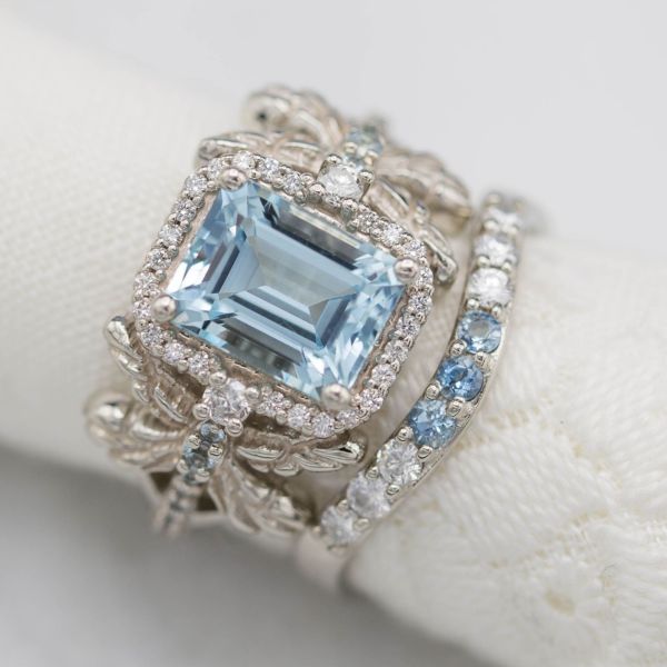 This dragonfly keeps the bold, sculptural design in balance with a Caribbean blue emerald cut aquamarine. The halo and a delicately curved aqua and diamond band give the rings timeless sparkle.