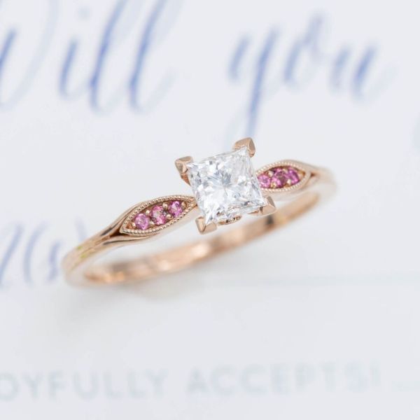 Pink tourmaline provides the perfect pop of accent color to this exquisitely delicate diamond engagement ring.