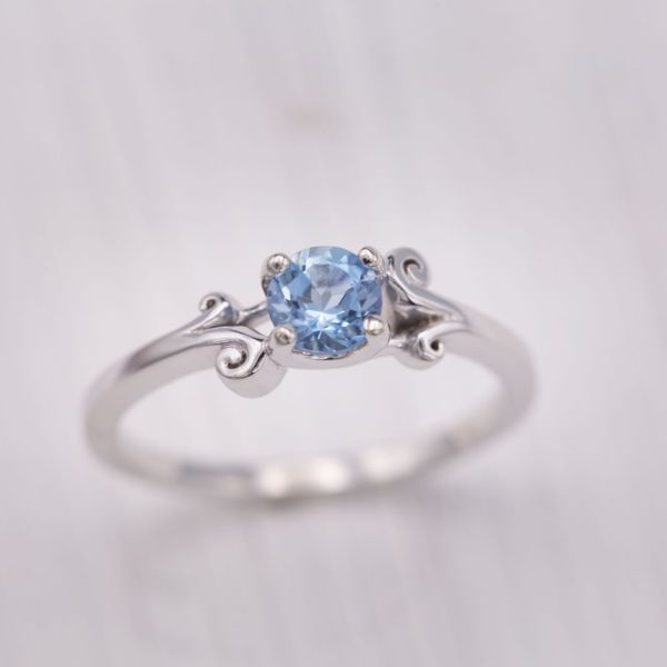 Curls of white gold crash like waves around the aquamarine center stone in this engagement ring.
