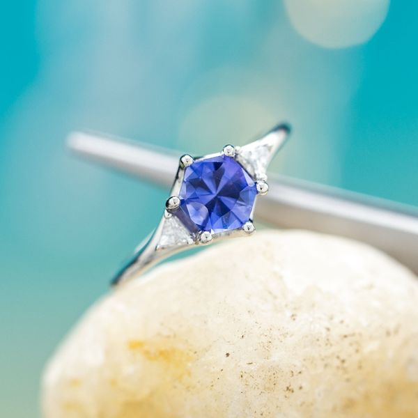 Beautifully geometric hexagon cut blue sapphire pairs with a softly tapered white gold band.