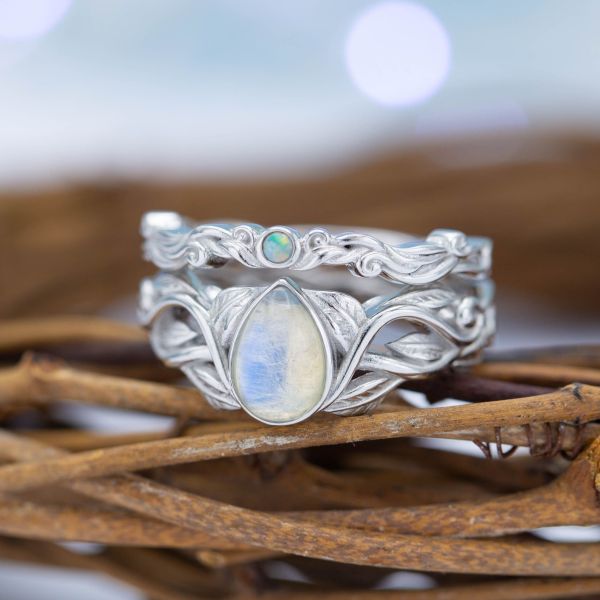 This nature-inspired bridal set features a pear cut moonstone and a small white opal with similar coloring on the matching band.