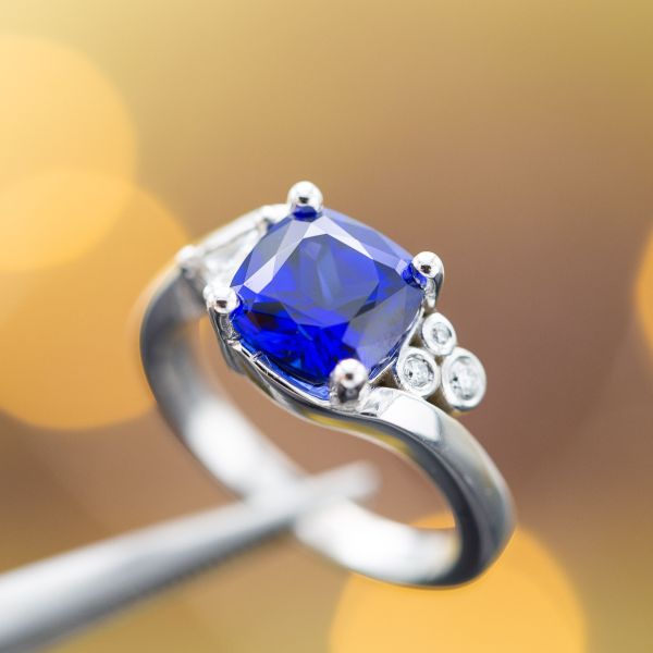 This cushion cut sapphire showcases the classic deep blue in a modern bypass setting.