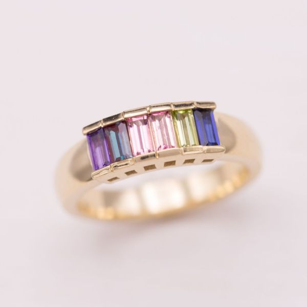 This step ring features two pink tourmaline baguettes surrounded by alexandrite, amethyst, peridot, and sapphire.