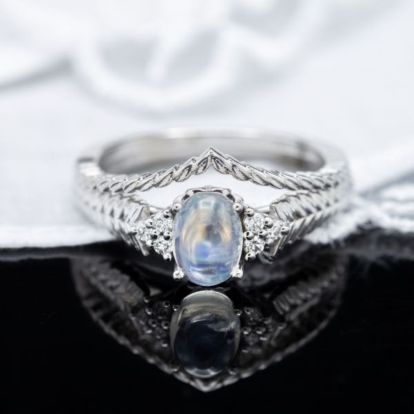 This bridal set surrounds a moonstone with a bit of diamond sparkle and a distinctive wheat texture detailing the band.