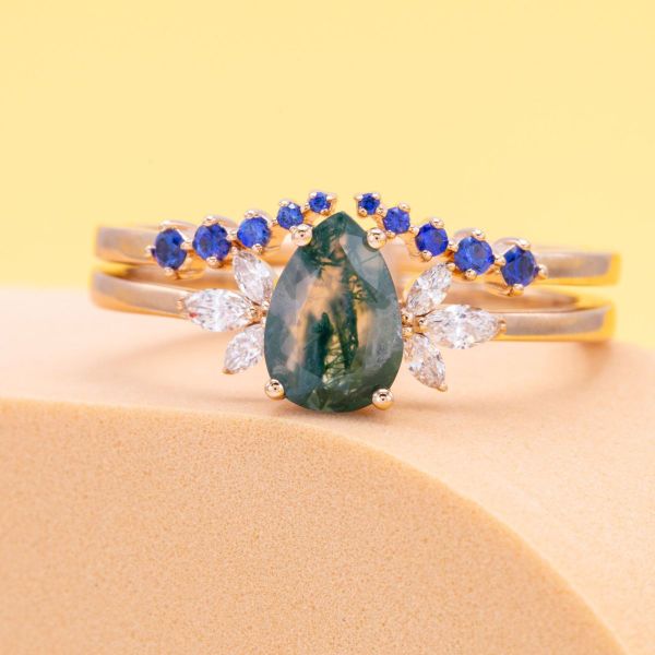 A sapphire wedding band? Yes, please! We set a collection of blue sapphires in an almost invisible rose gold to create a floating illusion wedding band. Sitting above the moss agate and lab-created diamond engagement ring, the sapphires look like raindrops falling over an enchanted forest.