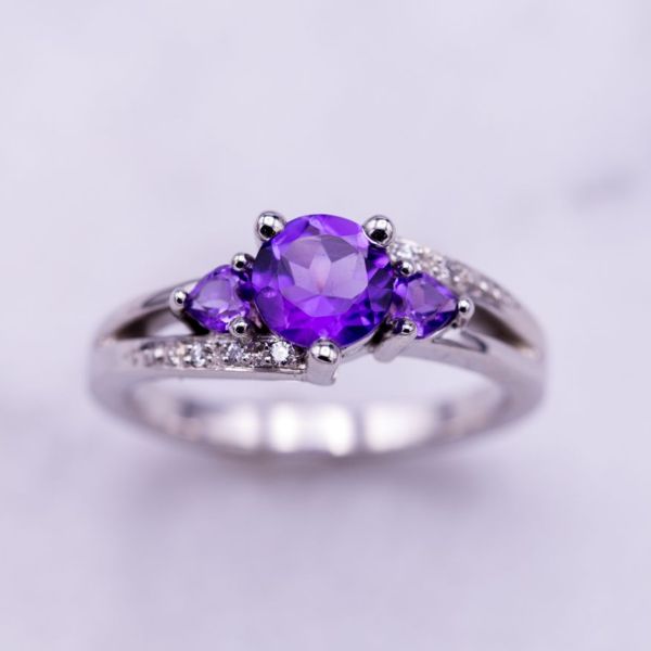 In this three-stone ring, royal purple amethyst contrasts beautifully with the white gold and diamonds around it.
