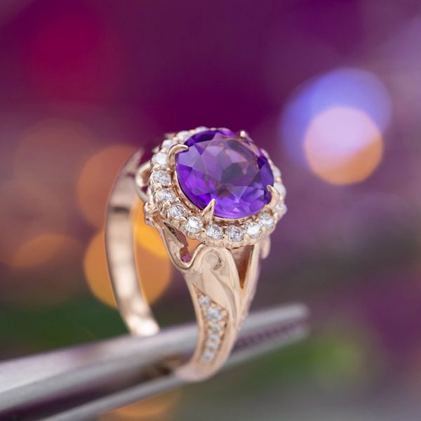 A halo of diamonds around a royal purple amethyst, all set on an elegant rose gold ring.