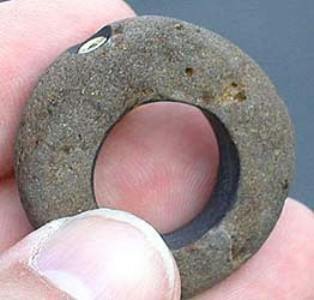 River rock with tube-set peridot, side view